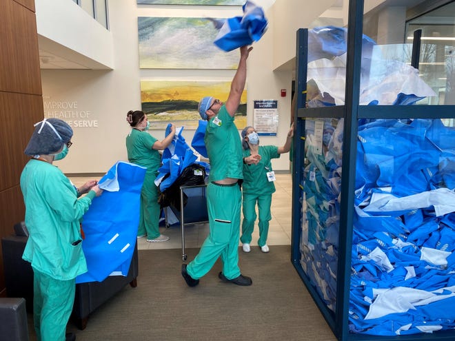 Employees fill a bin with blue surgical wrap at OhioHealth Marion General Hospital.